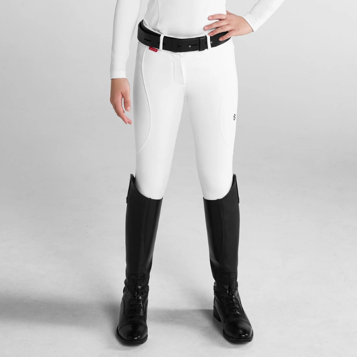 Person wearing white riding breeches on a grey background