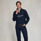 Man wearing a navy blue sweater with 'Holland Cooper' logo on a light grey background