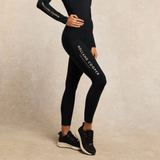 Person wears navy blue leggings with HOLLAND COOPER EQUESTRIAN branding on a neutral background