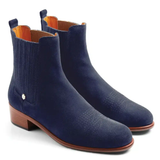 Pair of blue suede ankle boots with a small brown heel on a white background
