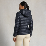 Person wearing a navy blue puffer jacket on a plain background