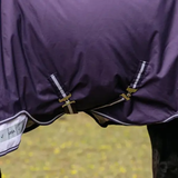 Close up of bell straps on a horse rug with a blurred outdoor background