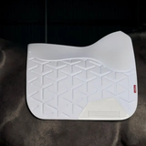 White textured saddle pad on a horse against a dark backgrounf