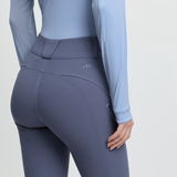 Person wearing a light blue long-sleeve top and grey-blue leggings on a light grey background