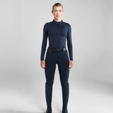 Person wearing a navy blue equestrian breeches on a light grey background