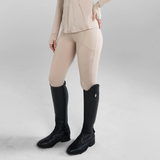 Person wearing beige riding breeches and black riding boots on a white background
