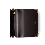 Black leather clutch with gold accents on a white background
