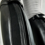 Close-up of a black leather riding boot with a zipper