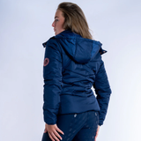 Person wearing a blue jacket with a visible brand logo on a white background