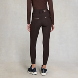 Person wearing brown equestrian leggings on a plain background