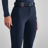 Navy riding breeches with a belt on a grey background