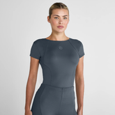 Woman wearing a grey athletic outfit on a light grey background