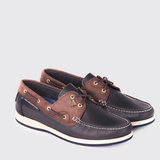Pair of brown and navy boat shoes on a light grey background