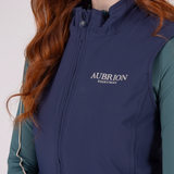 Navy blue vest with 'Aubrion Equestrian' logo worn by a person with red hair.