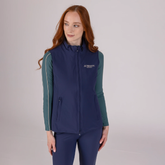 Woman wearing a navy blue gilet with a visible brand logo on a light grey background