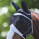 A horse wearing a black and blue Shires FlyGuard Pro Fine Mesh Fly Mask with ears.