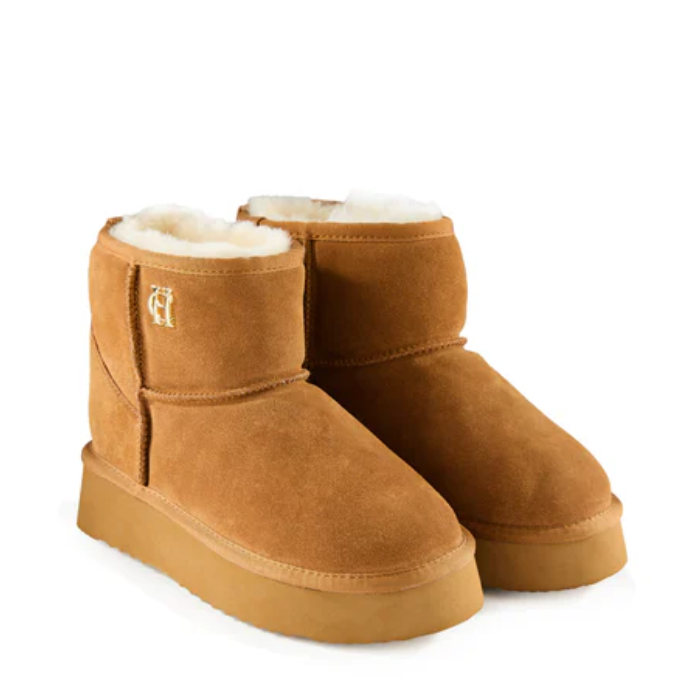 Pair of brown suede ankle boots with white fur lining on a white background