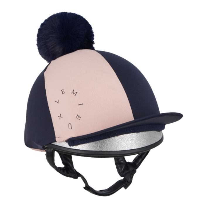 LeMieux AW26 Harlequin Hat Silk Variant Colour Navy/Petal.
A navy blue and blush pink equestrian riding helmet with a matching navy pom-pom on top, a black visor, and a silver glitter inner lining, shown against a plain white background.