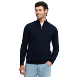 LeMieux AW26 Mens Quarter Zip Knit varient Navy. A man wearing a navy blue quarter-zip knit sweater with a small embroidered logo on the chest, paired with light blue jeans, against a plain white background.