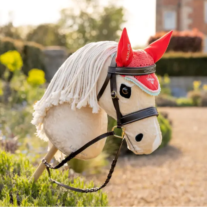 Toy horse with a red bandana and white mane in an outdoor setting