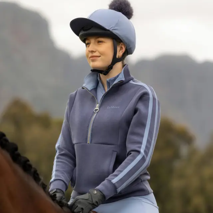 Rider wearing blue sweat shirt and blue covered hat faded background
