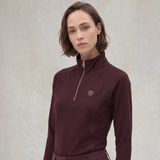 Holland Cooper Cranborne Long Sleeve Base Layer Variant Mulberry. Lady wearing a Mulberry base layer against a grey background with gold detailing. 