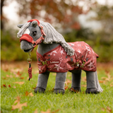 LeMieux AW26 Toy Pony Printed Turnout Rug Variant Colour Spiced Earth. A plush toy pony wearing a spiced earth colourtoy rug with star print on faded grass background.