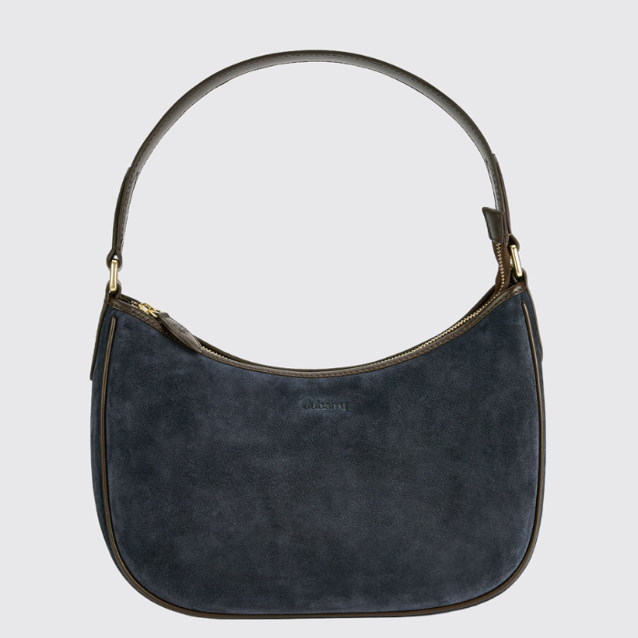 A dark navy blue suede crescent-shaped shoulder bag with gold-tone hardware and a curved top handle, shown against a light gray background.