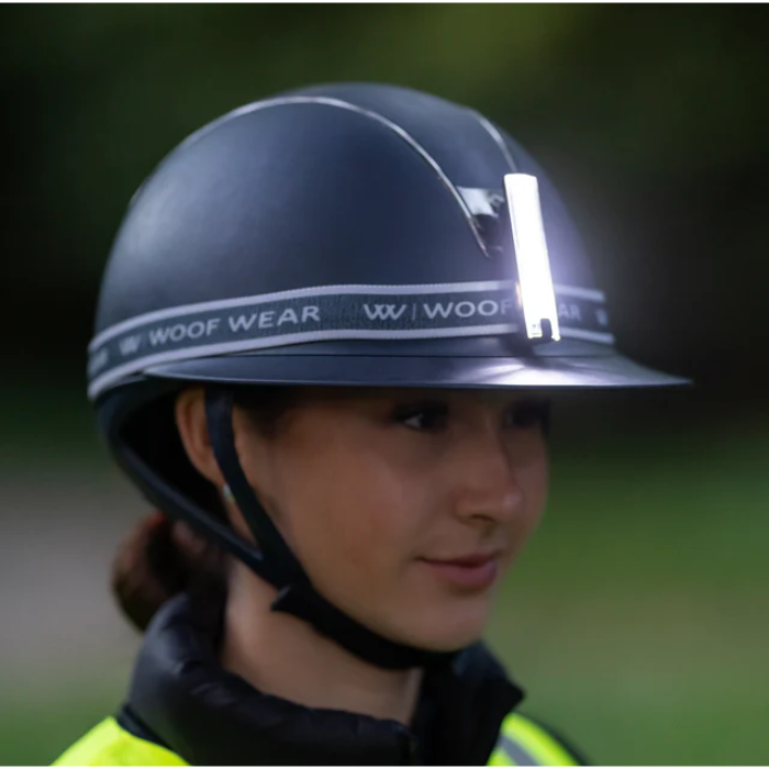 Person wearing a Woof Wear helmet with a blurred green background