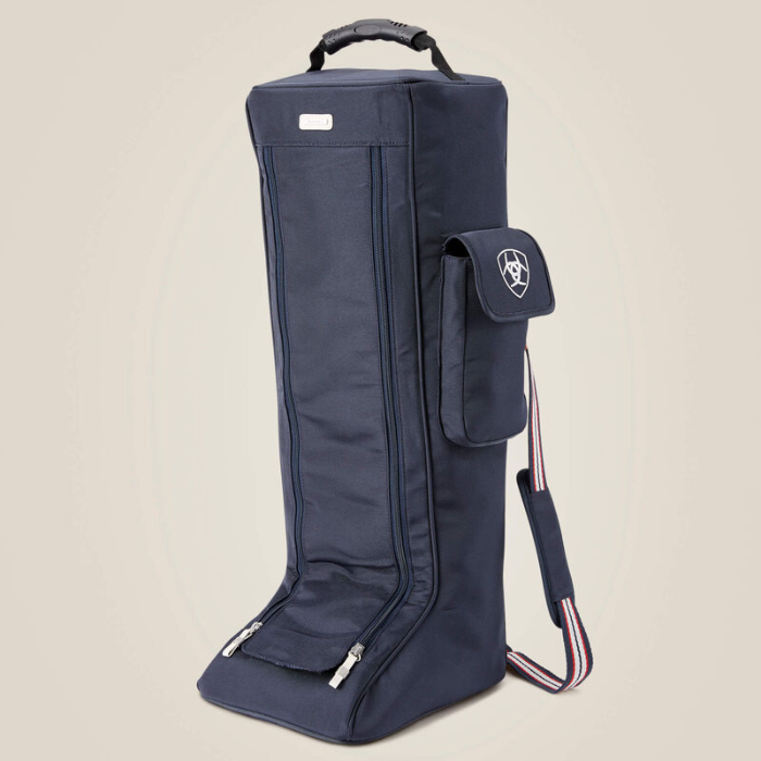 A Navy boot bag with a small side pocket and a red and blue striped handle on a beige background. 