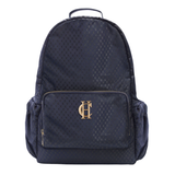 Holland Cooper Burghley Backpack Variant Ink Navy Monogram. A dark navy blue backpack with a subtle repeating monogram pattern, featuring a front zippered pocket with a gold-tone 'HC' logo and side pockets, set against a plain white background.