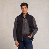 Holland Cooper Country Fleece Gilet (Men's) Variant Ink Navy. Man wearing navy gilet with brown detailing over a cheque shirt on a grey background. 