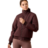 Ariat Women's Stable 2.0 Insulated Jacket Varient Chocolate Plum. Woman wearing a brown bomber coat and brown trousers on a white background. 