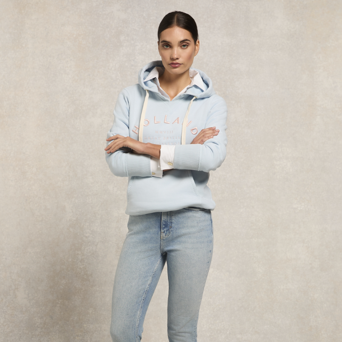 Woman styles the Holland Cooper Varsity Hoodie in Pale Blue with jeans