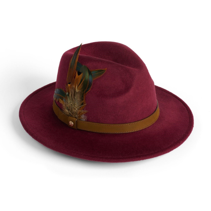 Maroon fedora hat with a brown band and feather decoration on a white background
