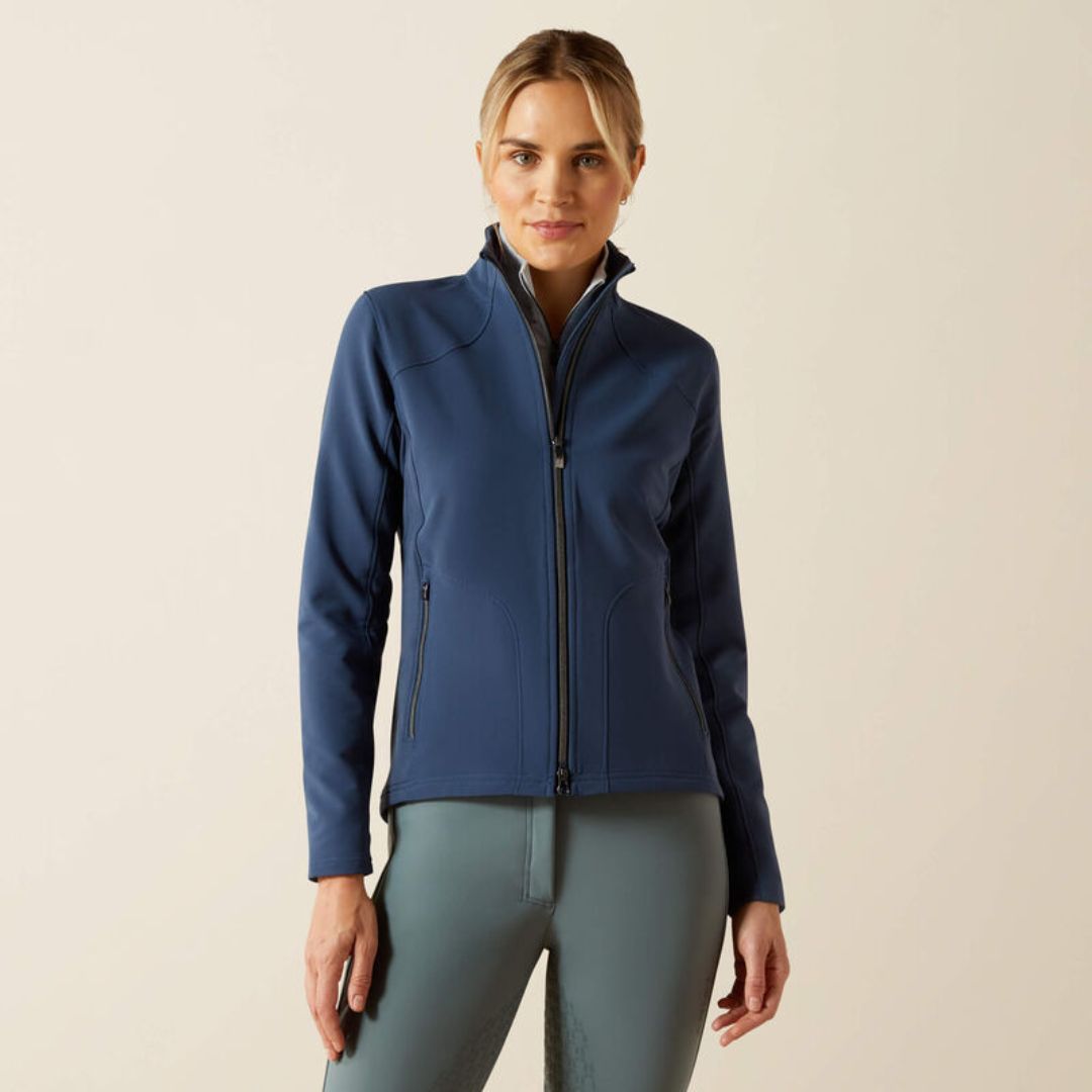 Woman wearing a blue jacket and grey leggings on a beige background