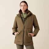 Lady wearing a olive coloured jacket with a dark green zip and big pockets against a beige background. 