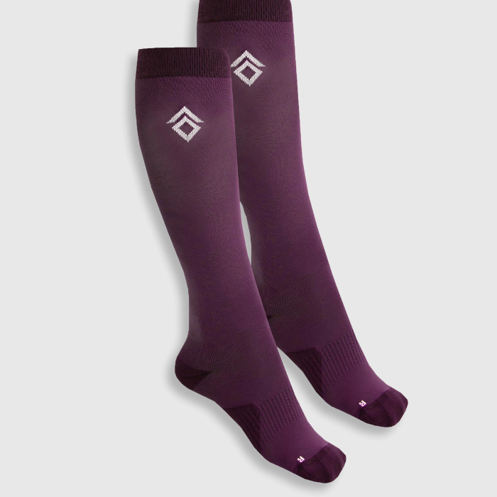 Aztec Diamond Pressure Padded Socks-Twin Pack AW26 Variant Ash Plum. A pair of knee-high athletic socks in a deep plum purple color, featuring a white geometric diamond logo on the upper calf and a small white logo on the toes, displayed against a light gray background.