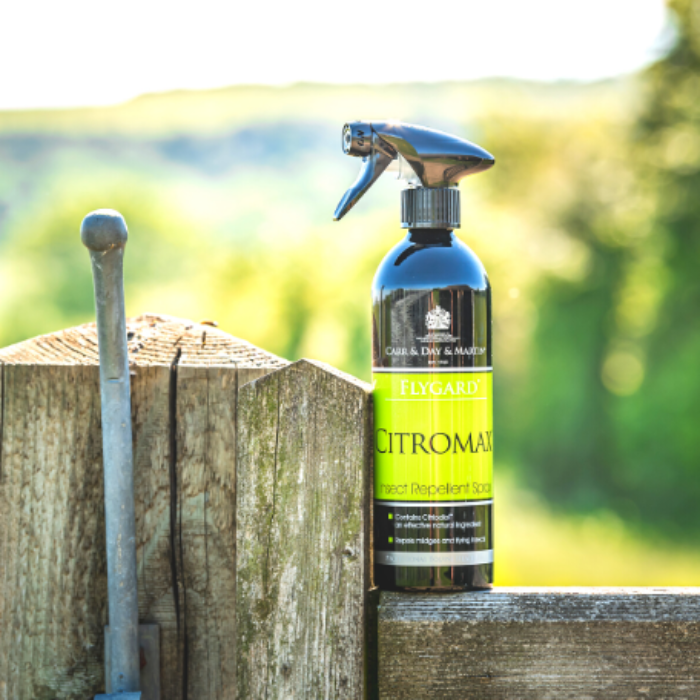 Black and green bottle on gate of fly repellent