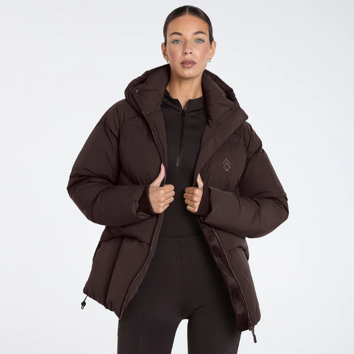 Aztec Diamond Matt Puffer AW26 Variant Espresso. Lady wearing Brown matt puffer jacket with small Aztec Diamond logo on a white background. 