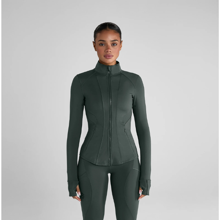 person with pale green jacket on grey back ground