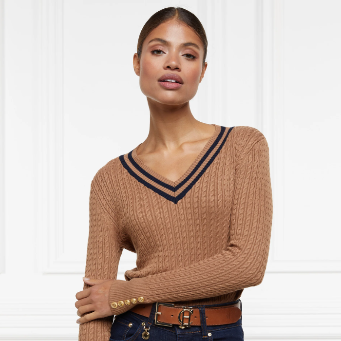 Holland Cooper Zoe Knit Jumper Variant Dark Camel. Woman wearing a camel coloured jumper with gold button detailing on a white background. 
