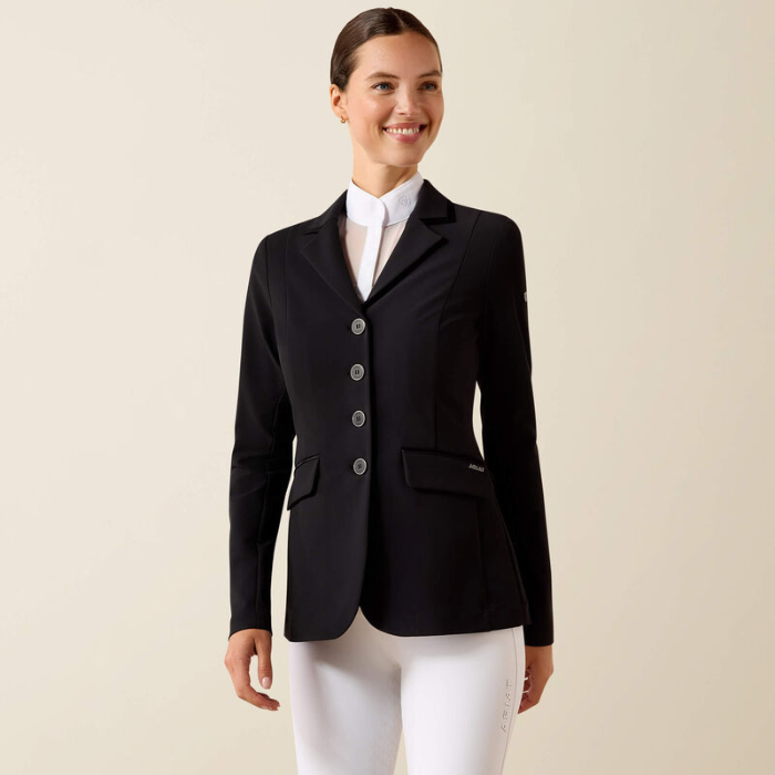 Woman wearing a black blazer over a white shirt and pants on a beige background