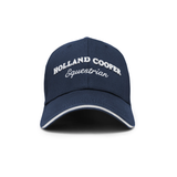 Holland Cooper HC Equestrian Cap Variant Ink Navy. Navy baseball cap with Holland Cooper branding in white with white trim detailing against a white background. 
