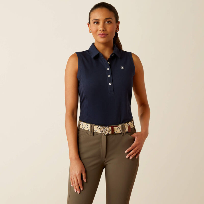 Woman wearing a navy sleeveles polo shirt on a beige background