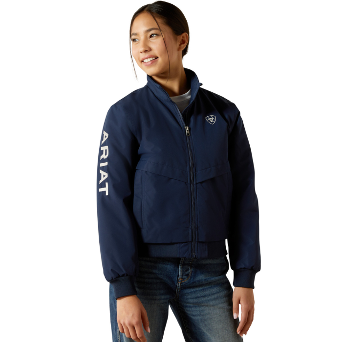 Ariat Youth 2.0 Insulated Stable Jacket Varient Navy. Girl wearing navy jacket with Ariat branding down the sleeve on a white background. 