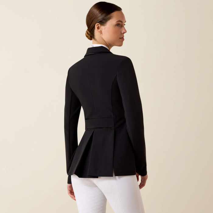 Woman wearing a black blazer and white pants on a beige background