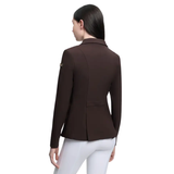 Woman wearing a brown blazer and white pants on a white background