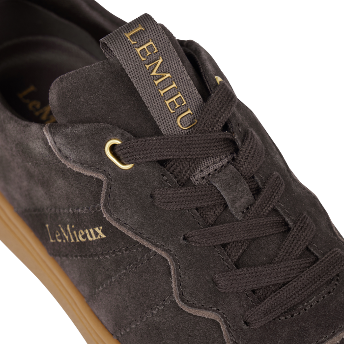 LeMieux AW26 Stockbridge Suede Trainers Variant Colour Cocoa. A close up of a brown suede shoe with 'LeMieux' brand name is gold colour. on white background.