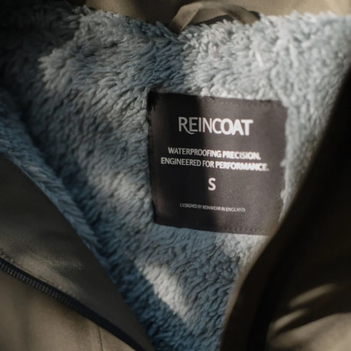 Reincoat Smock Pro Variant Olive. Inside of a Olive jacket with a fleece lining and 'REINCOAT' label. 
